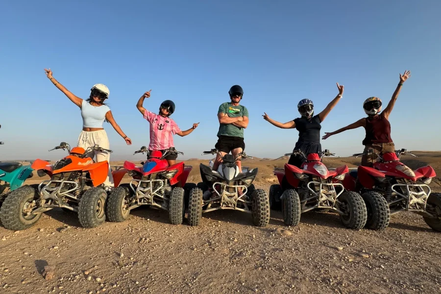 Group quad biking across the tracks of the Agafay desert at sunset